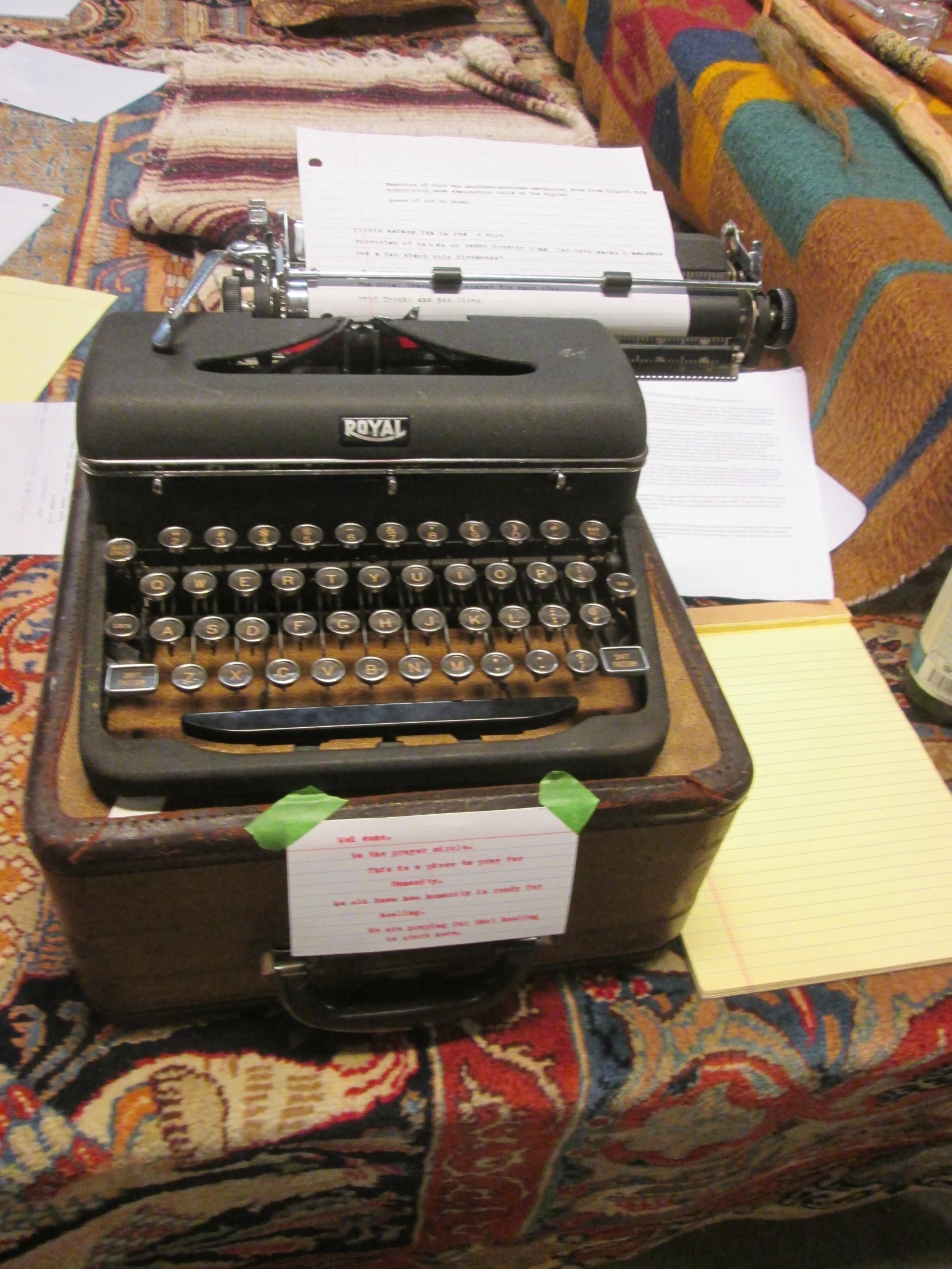 an old typewriter sitting on a patterned table cloth