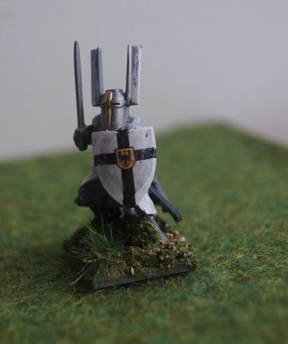 small figurine wearing armor and holding two swords