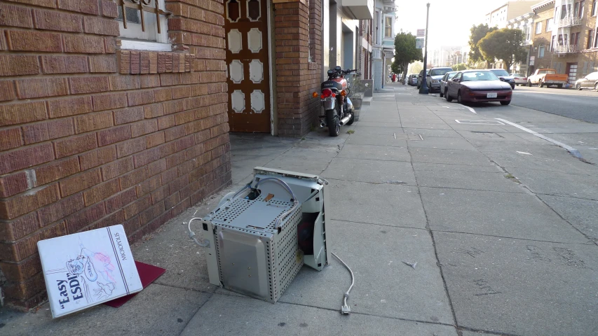 a box sitting in front of a brick building on a sidewalk
