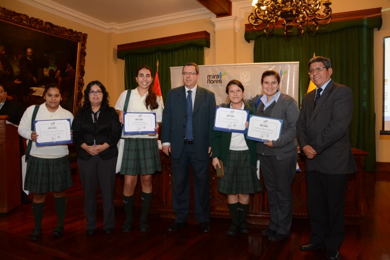 a group of people standing next to each other holding certificates