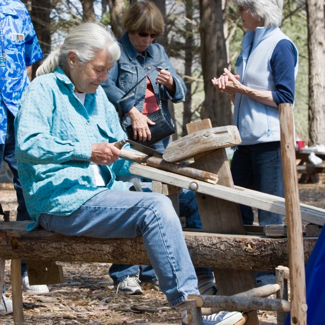 an elderly woman sitting on a bench next to a bench