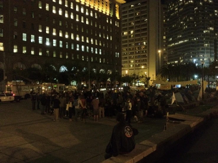 a night time picture of people gathered at a place in the city