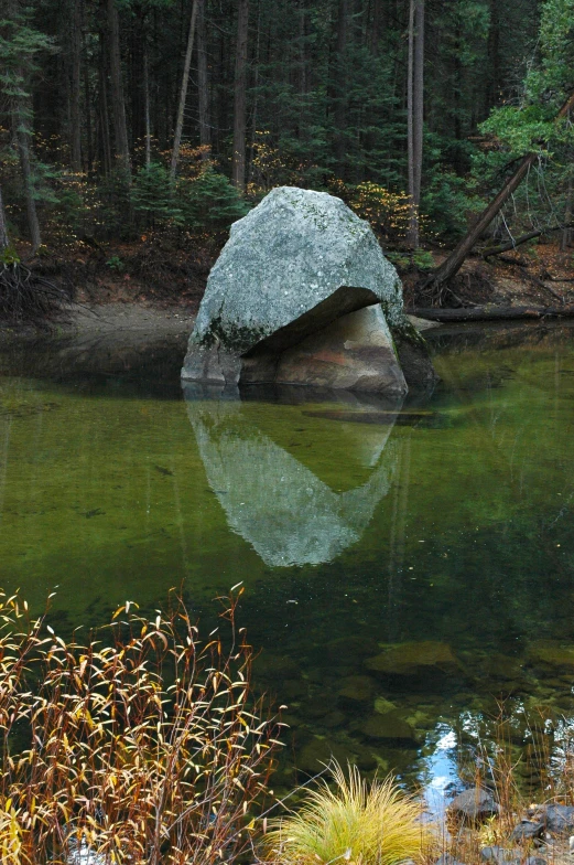 some rocks are by the water in a lake