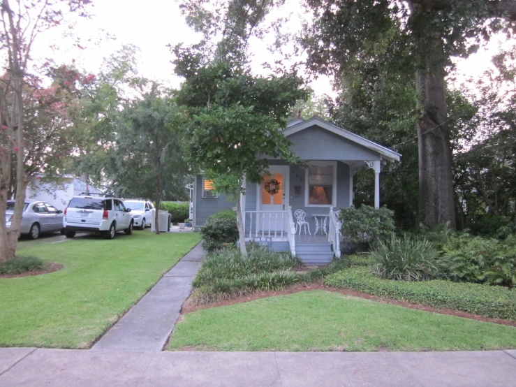 a little blue cottage with an orange door