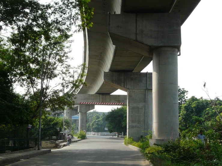 a walkway going under a large structure with many trees