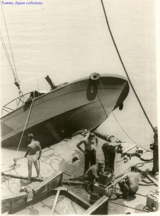 a couple of men standing on top of a boat