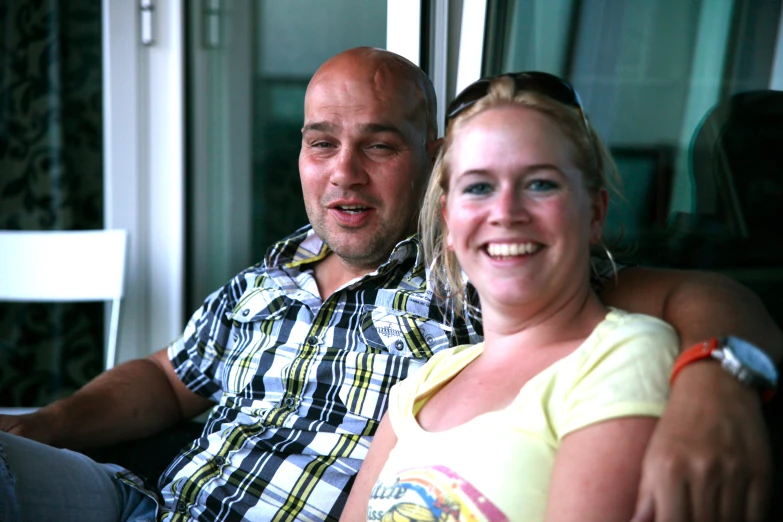 a man sitting next to a woman on top of a couch