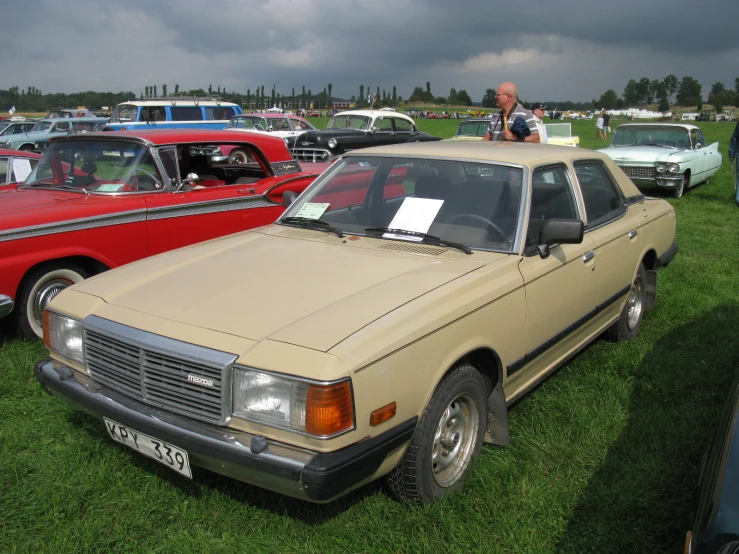 an old fashion car is parked on some grass