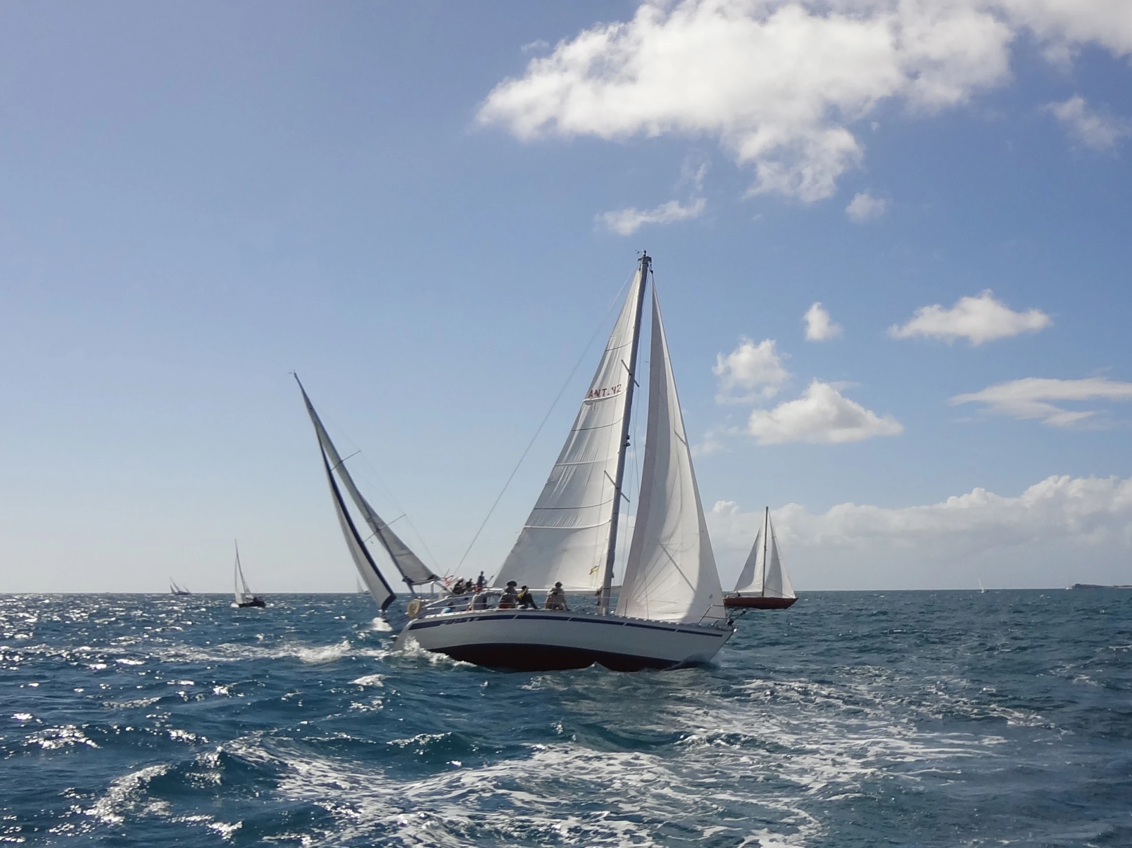 two boats in the ocean sailing on a sunny day