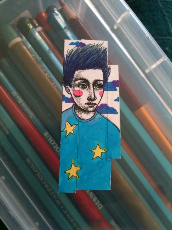 an image of a  with a blue shirt and some colored pencils