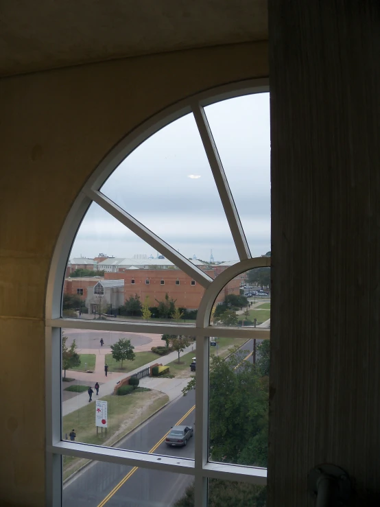 an oval window in a building with people outside