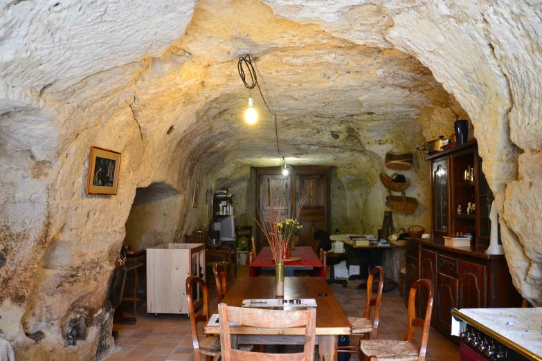 a kitchen and dining room in an old style cave