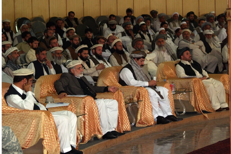 a large group of people are sitting down in chairs