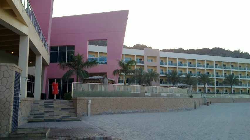 a building with a staircase leading to a pink wall