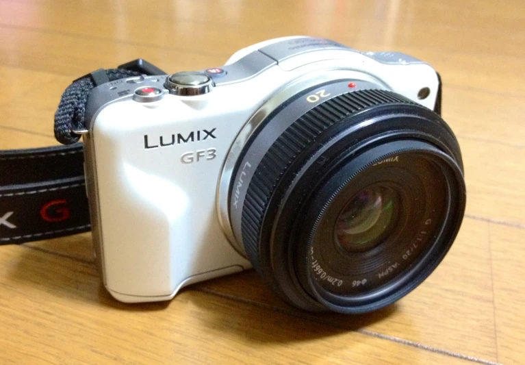 the white camera is set up on the wood table