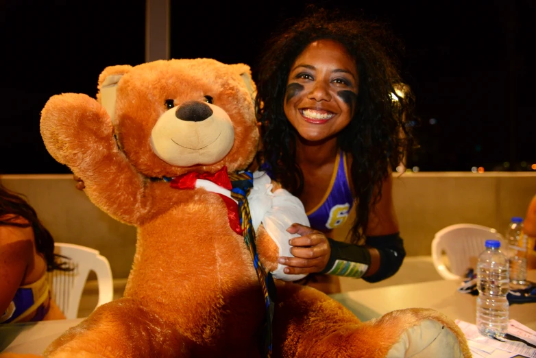 a woman poses next to her stuffed teddy bear