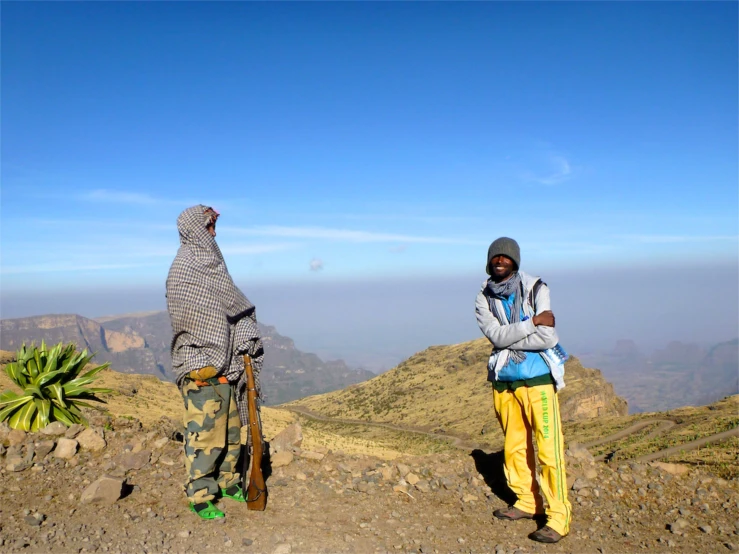 two people standing on top of a mountain top