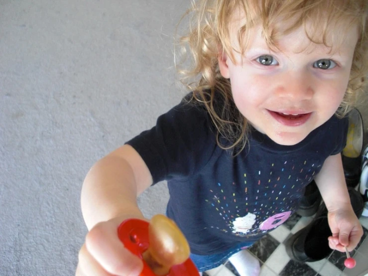 a close up of a child holding a toy