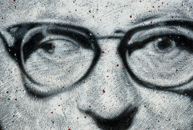 a drawing of a face with glasses drawn by graffiti