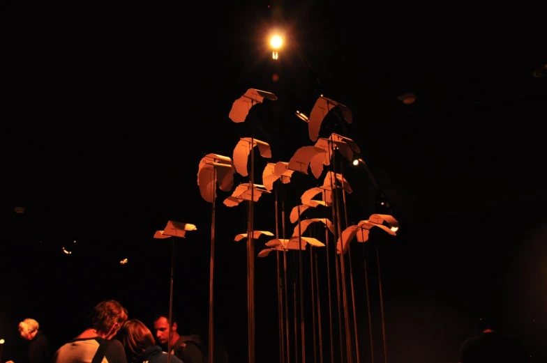 a display featuring a row of lit candles with a sculpture of several birds