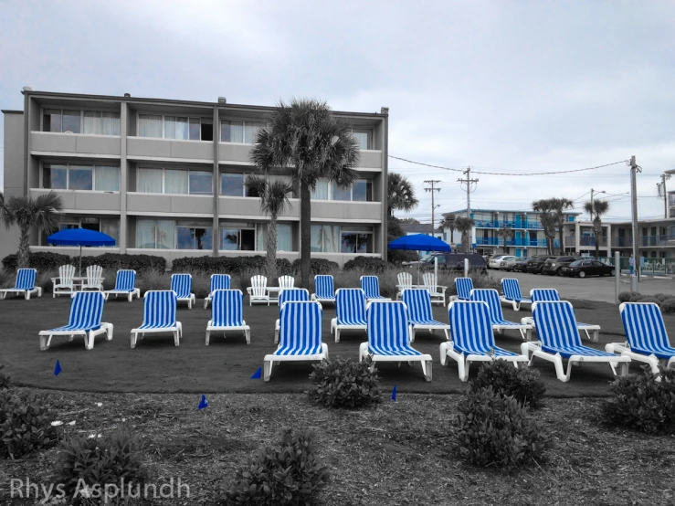 many blue and white chairs are in front of the motel