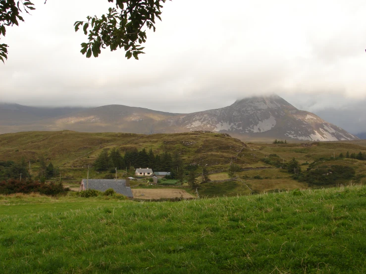 the countryside of a small village is shown under a cloudy sky