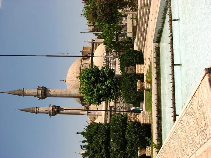 the exterior of a mosque is shown near a fountain