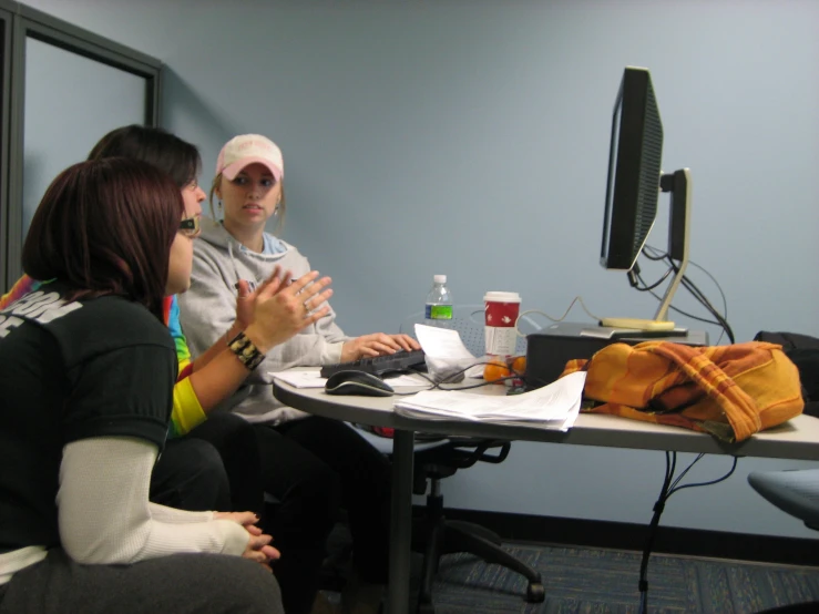 a group of people sitting around a table and talking