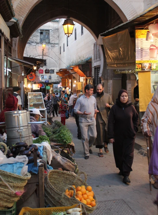 people walk through an alley way in a crowded street