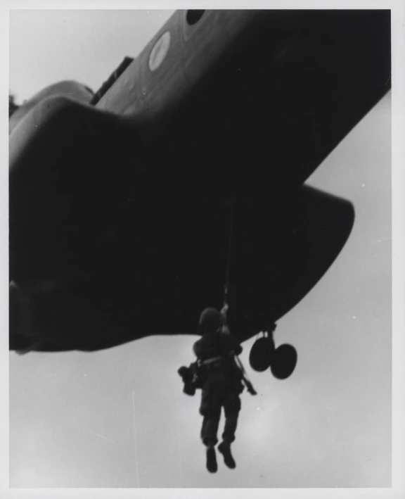 a person in the air in front of an airplane