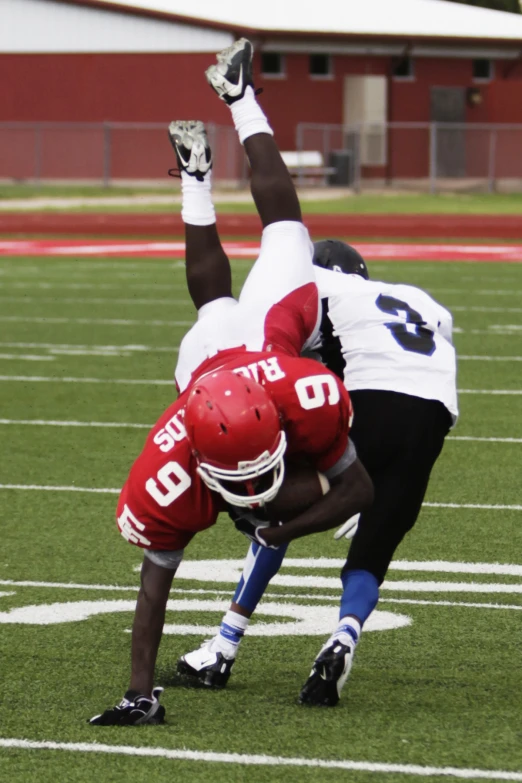 two men playing football while on a field