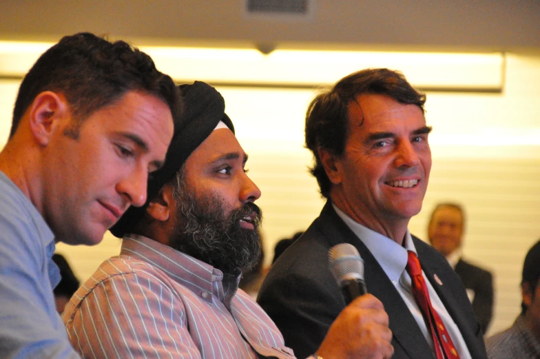 three men sitting next to each other with microphones