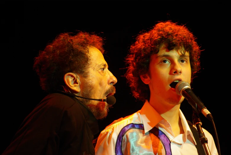 two men wearing neck ties are on stage