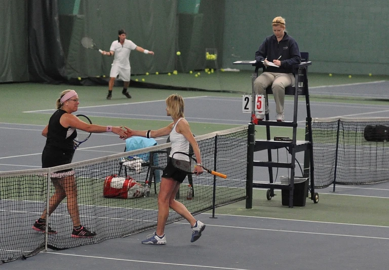 a woman and a man are standing on a tennis court