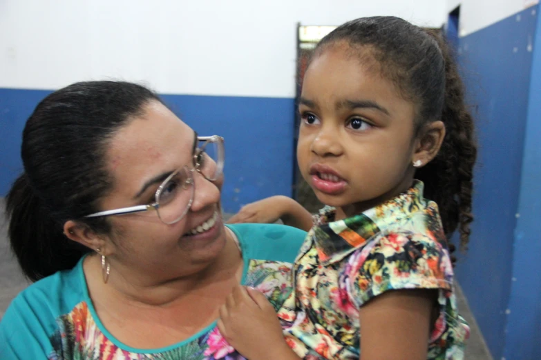 a little girl getting her ear checked by an adult