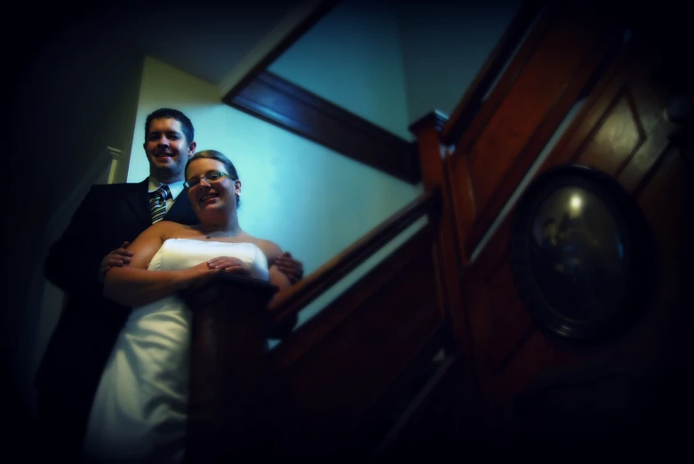 couple standing by stair way together posing for a picture