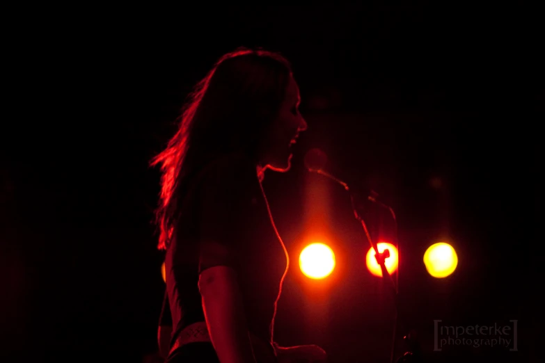 a beautiful woman holding a microphone in her hand