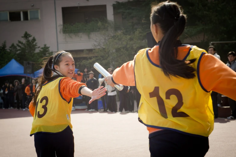 two young women are playing softball with each other