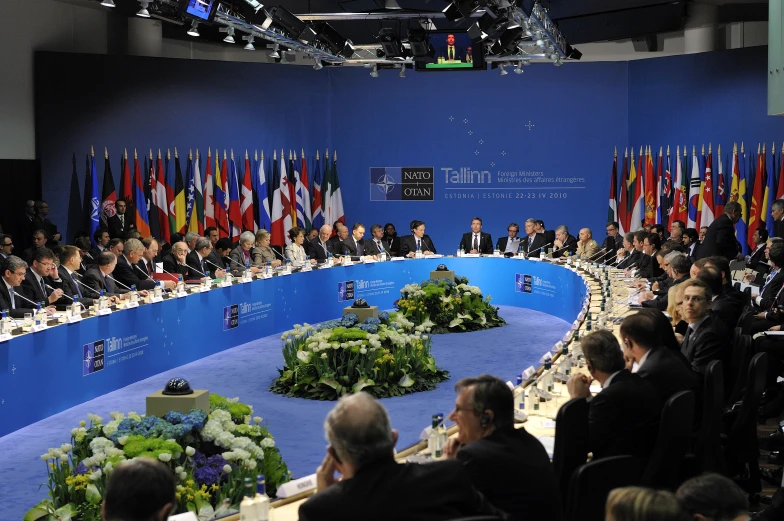 several people sitting at tables with their flags and signs in front of them