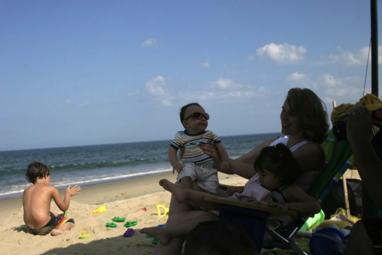 a family sitting on the beach together