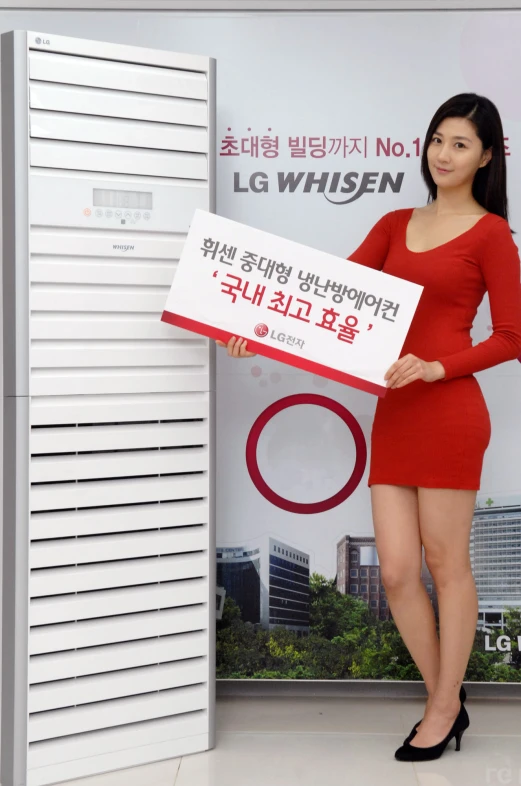 a young woman standing next to a white door holding a sign