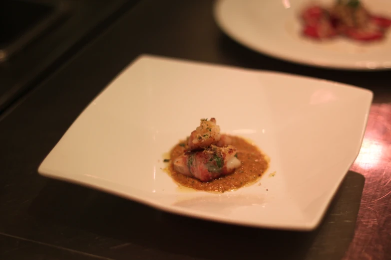 an appetizer dish displayed in a white square plate