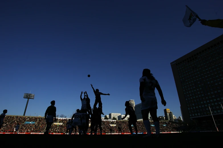 people playing tennis on a sunny evening in the city