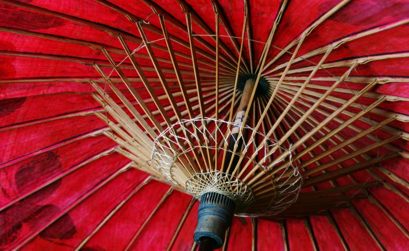 a red umbrella sitting open on top of a white surface