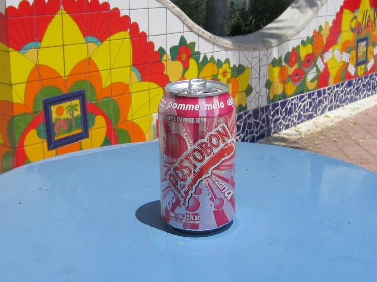 a soda can that is sitting on a blue table