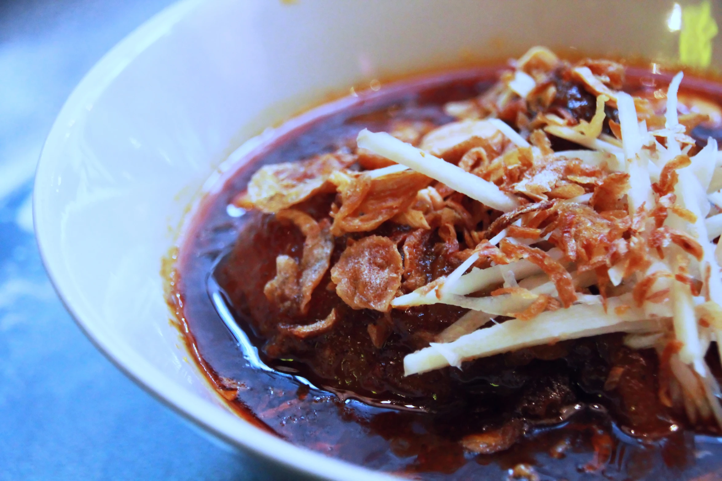 a dish of pasta and meat in a sauce with onions