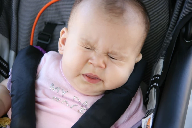 the baby is in the stroller with a small hand on her chest