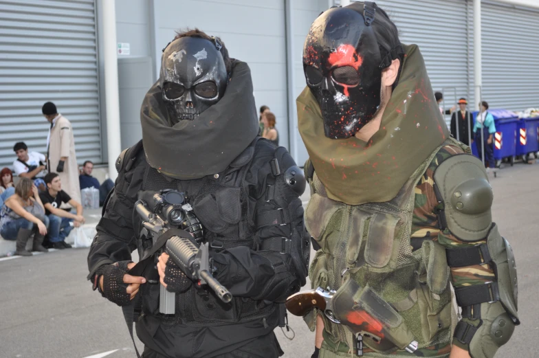 two men in face paint wearing masks and holding guns