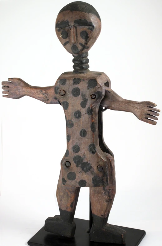 a wooden statue of a man with dots