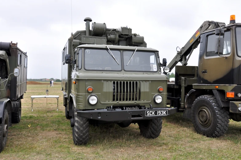 military vehicles parked in the middle of a grassy field